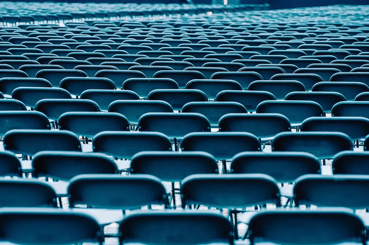 Rows upon rows of empty teal chairs