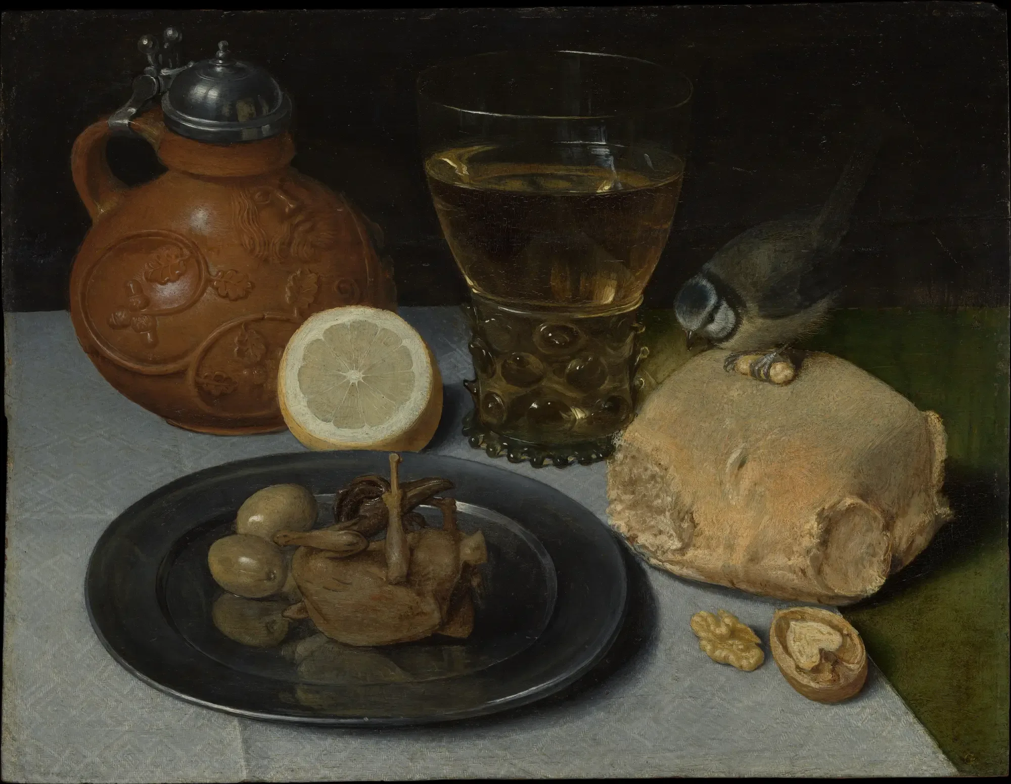 Painting of a stoneware jug, a glass of wine, a peeled lemon and bread on a pewter plate