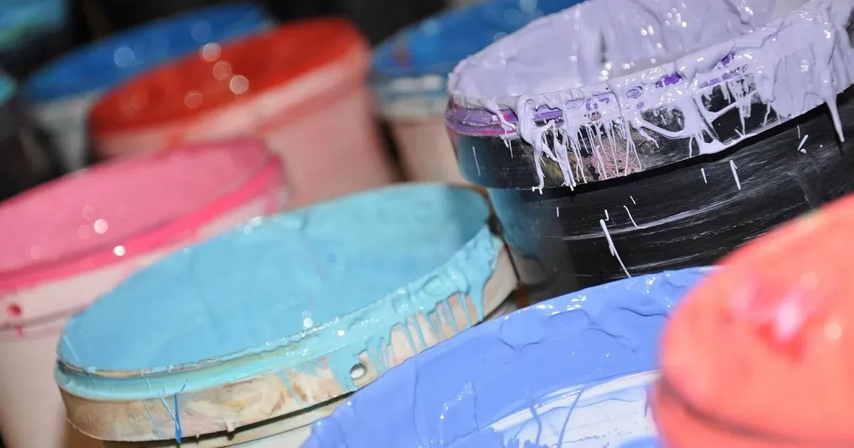 Open tubs of screen-printing ink in pink, sky blue, coral, lilac and black