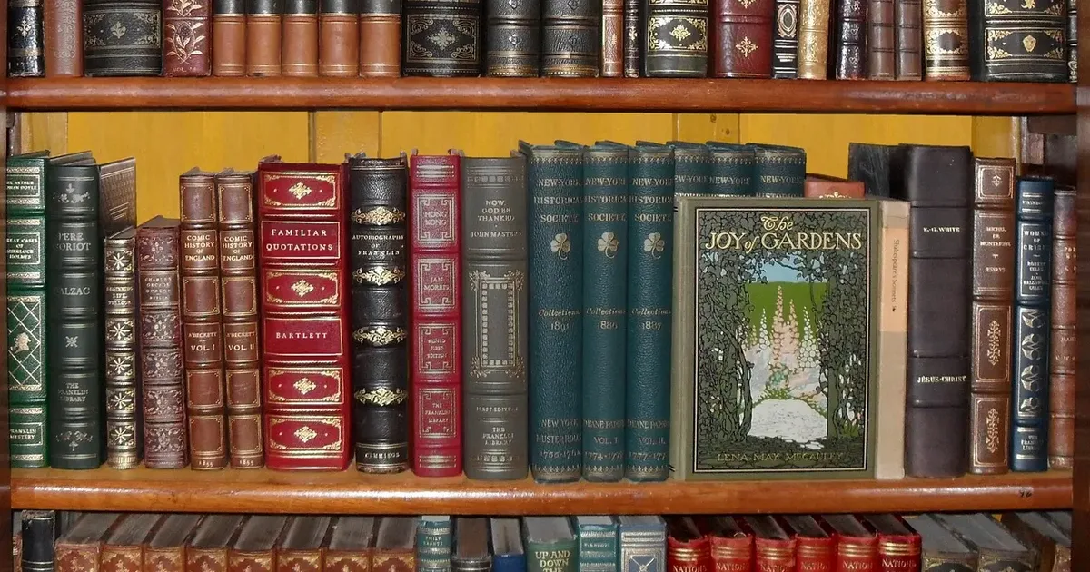 Shelves of old leather-bound books with gilt spines